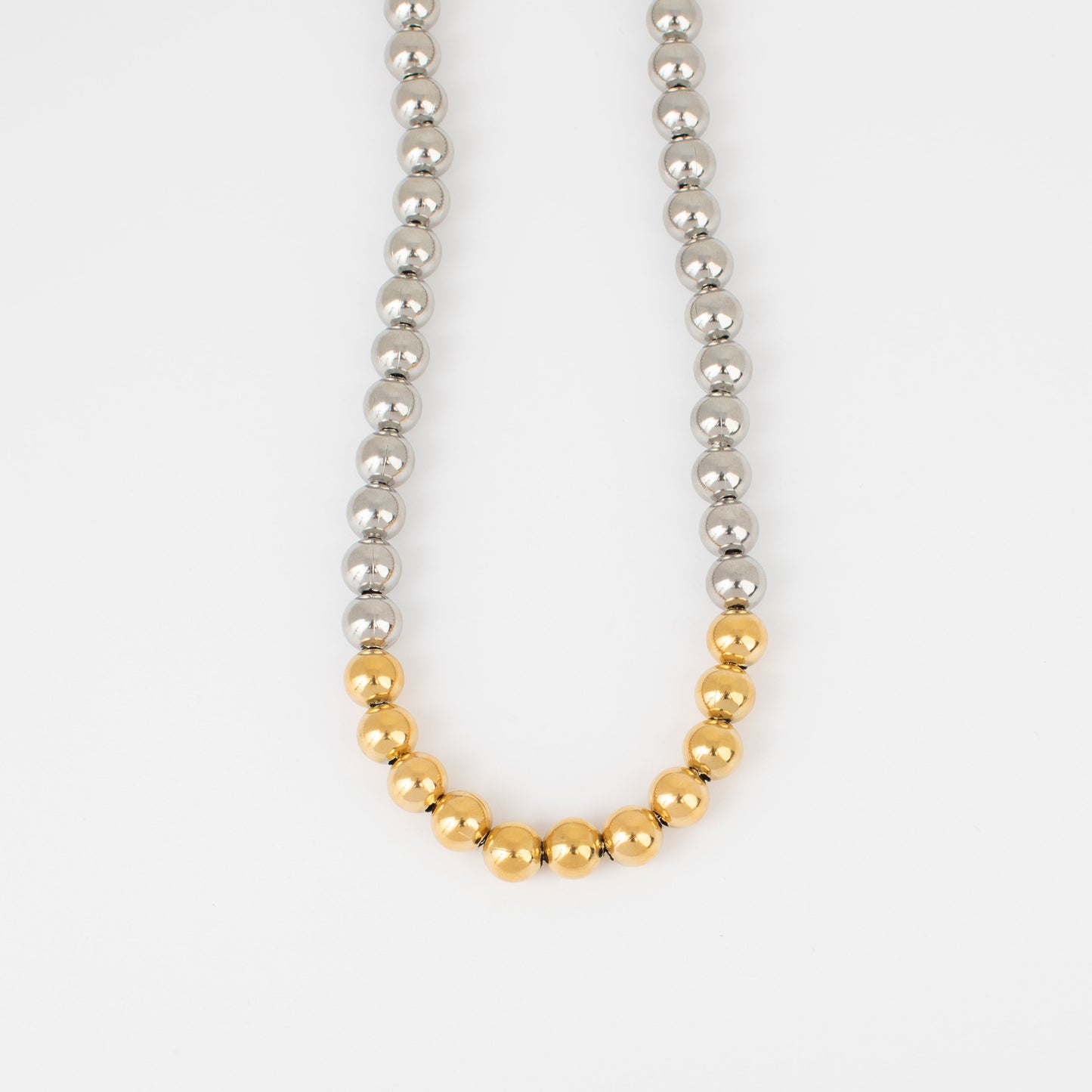 Necklace with alternating silver and gold beads on a white background