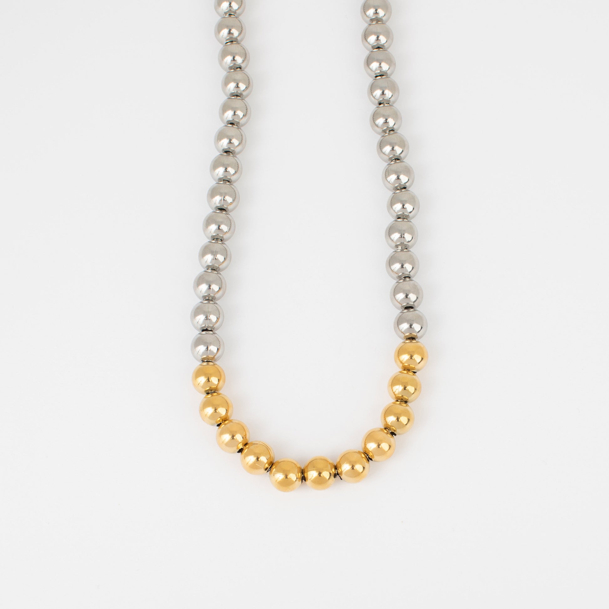 Necklace with alternating silver and gold beads on a white background