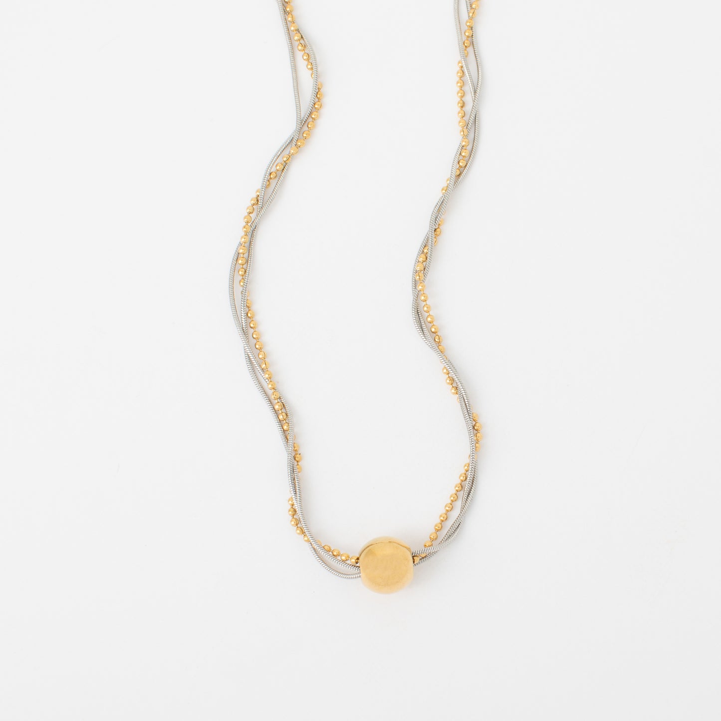 Gold necklace with a round pendant on a white background