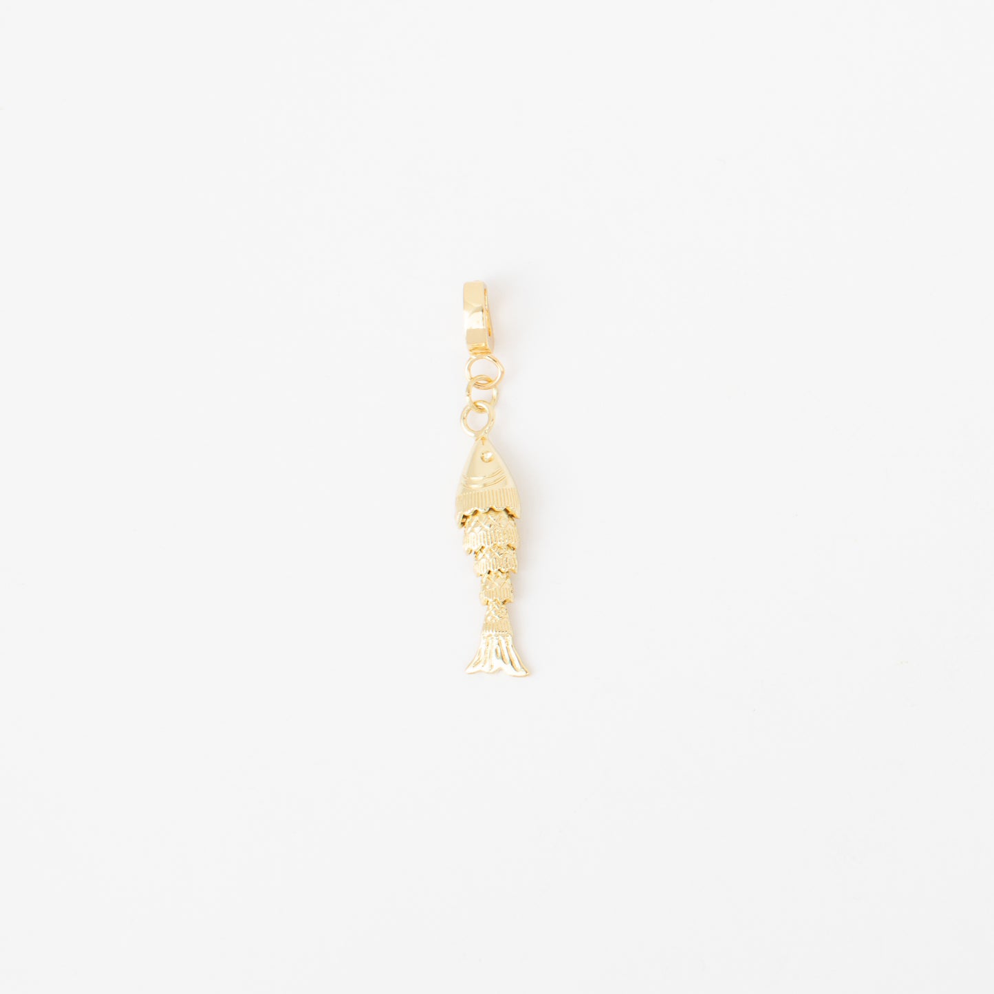 Gold fish-shaped charm on a white background