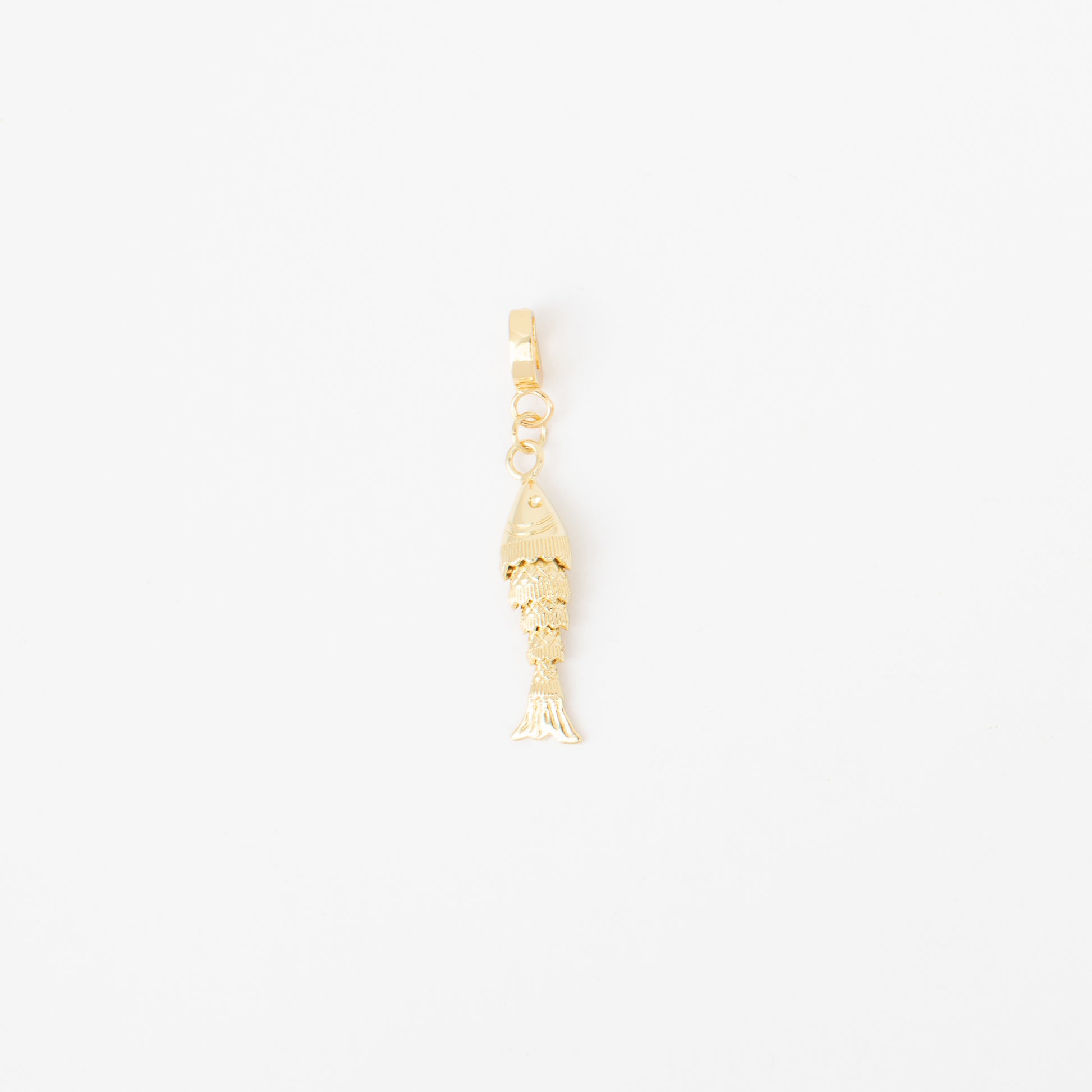 Gold fish-shaped charm on a white background