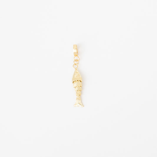 Gold fish-shaped charm on a white background
