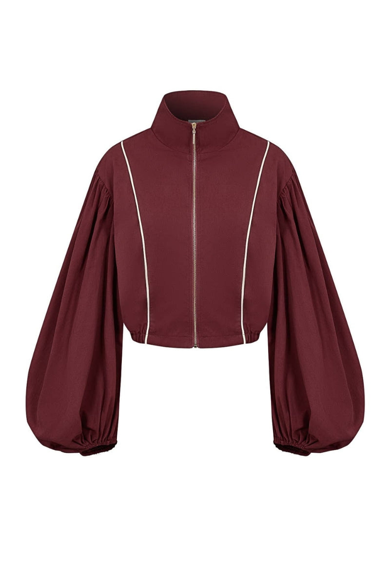 A cropped zip-up jacket in deep burgundy with dramatic balloon sleeves and thin white piping details, shown against a plain white background.