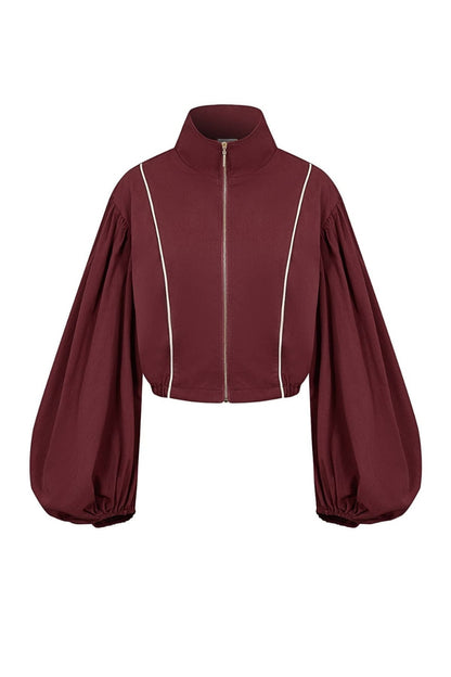 A cropped zip-up jacket in deep burgundy with dramatic balloon sleeves and thin white piping details, shown against a plain white background.