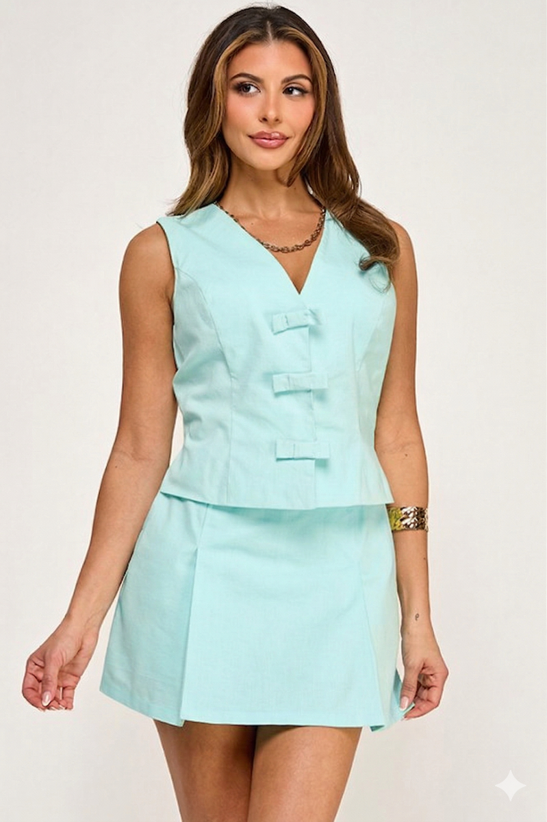Woman wearing a light blue sleeveless top and skirt set on a white background