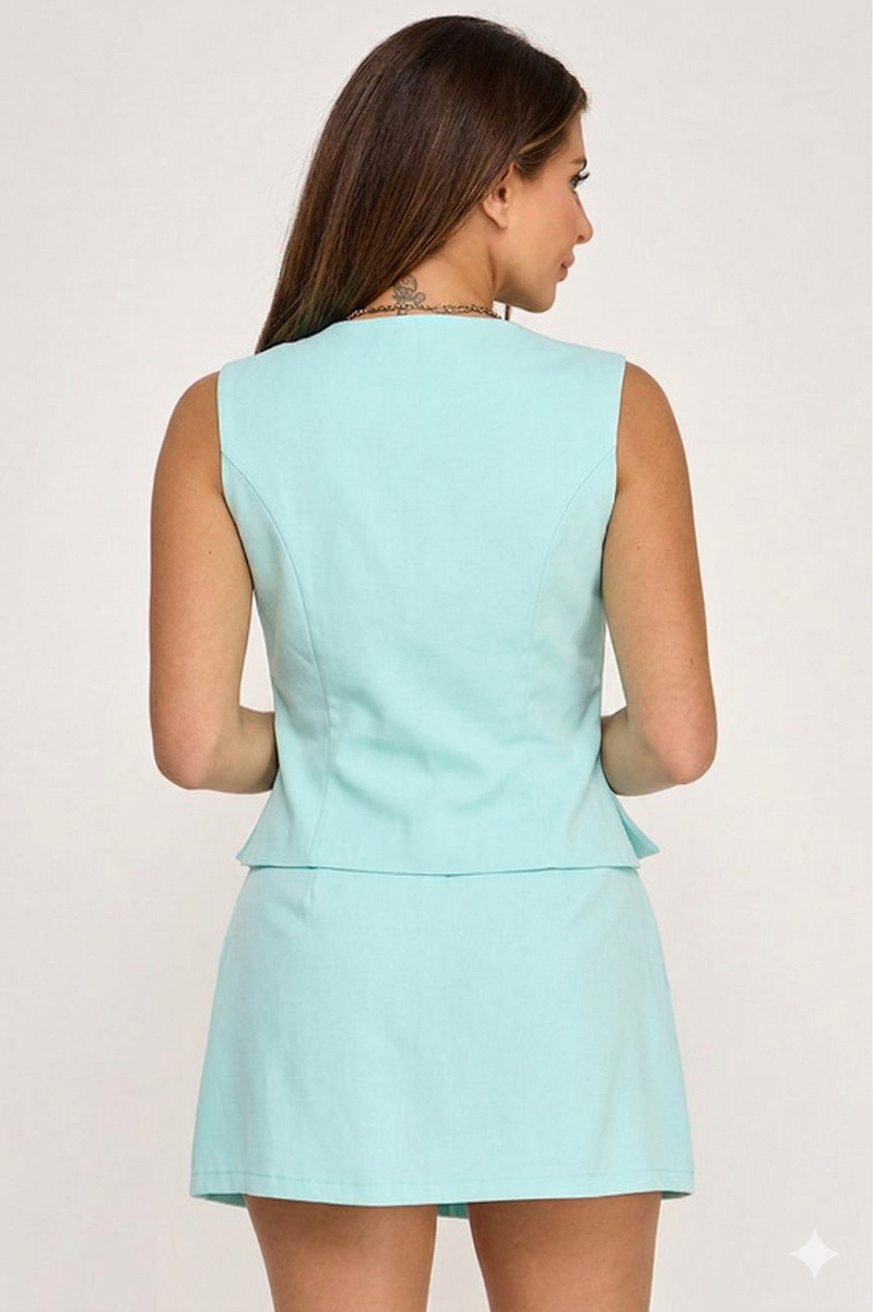 Woman wearing a light blue sleeveless dress against a white background