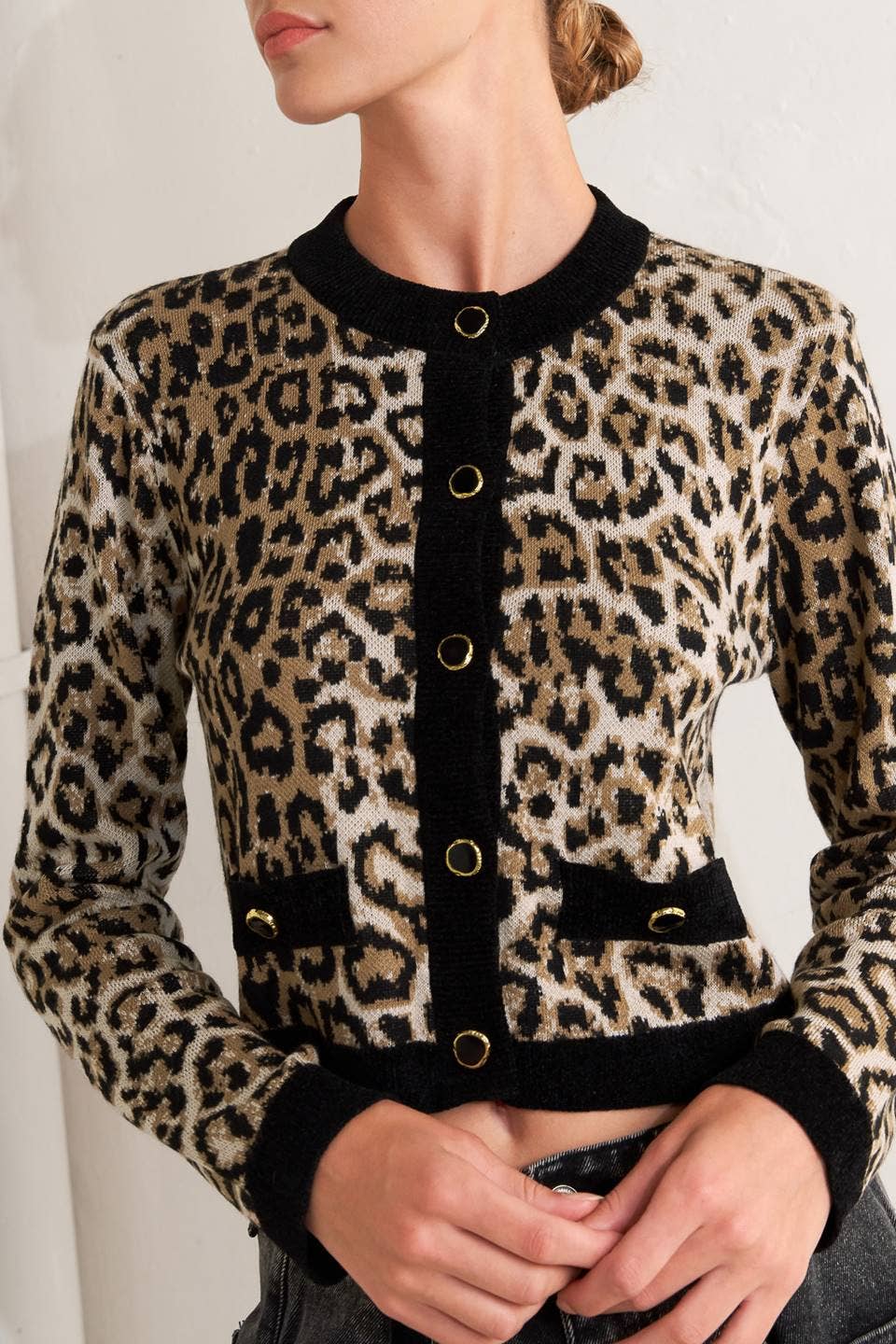 Leopard print jacket with black trim worn by a person against a neutral background