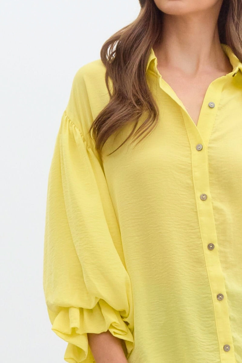 Yellow shirt worn by a person on a light gray background