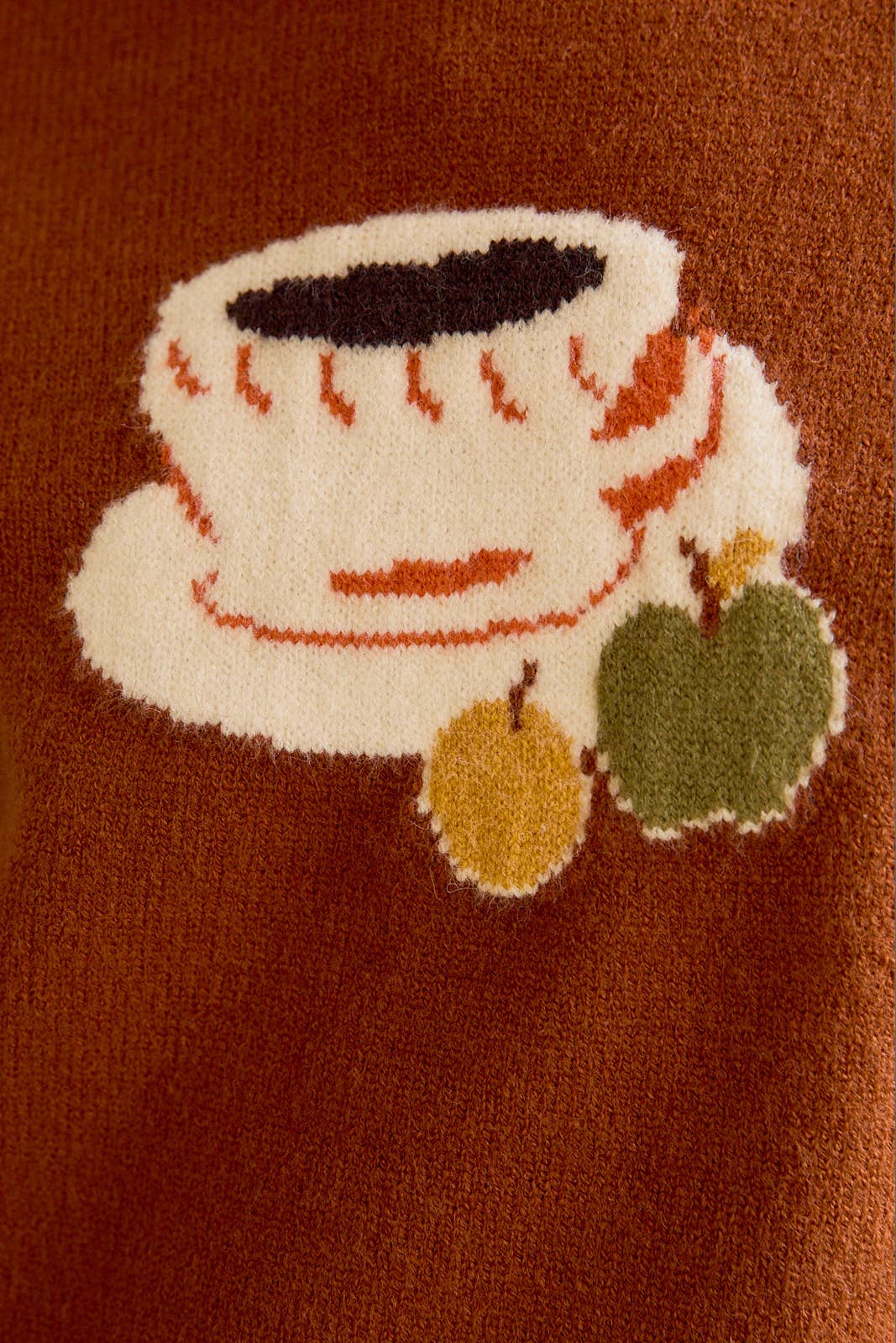 Close-up of a textured fabric with a tea cup and saucer design.