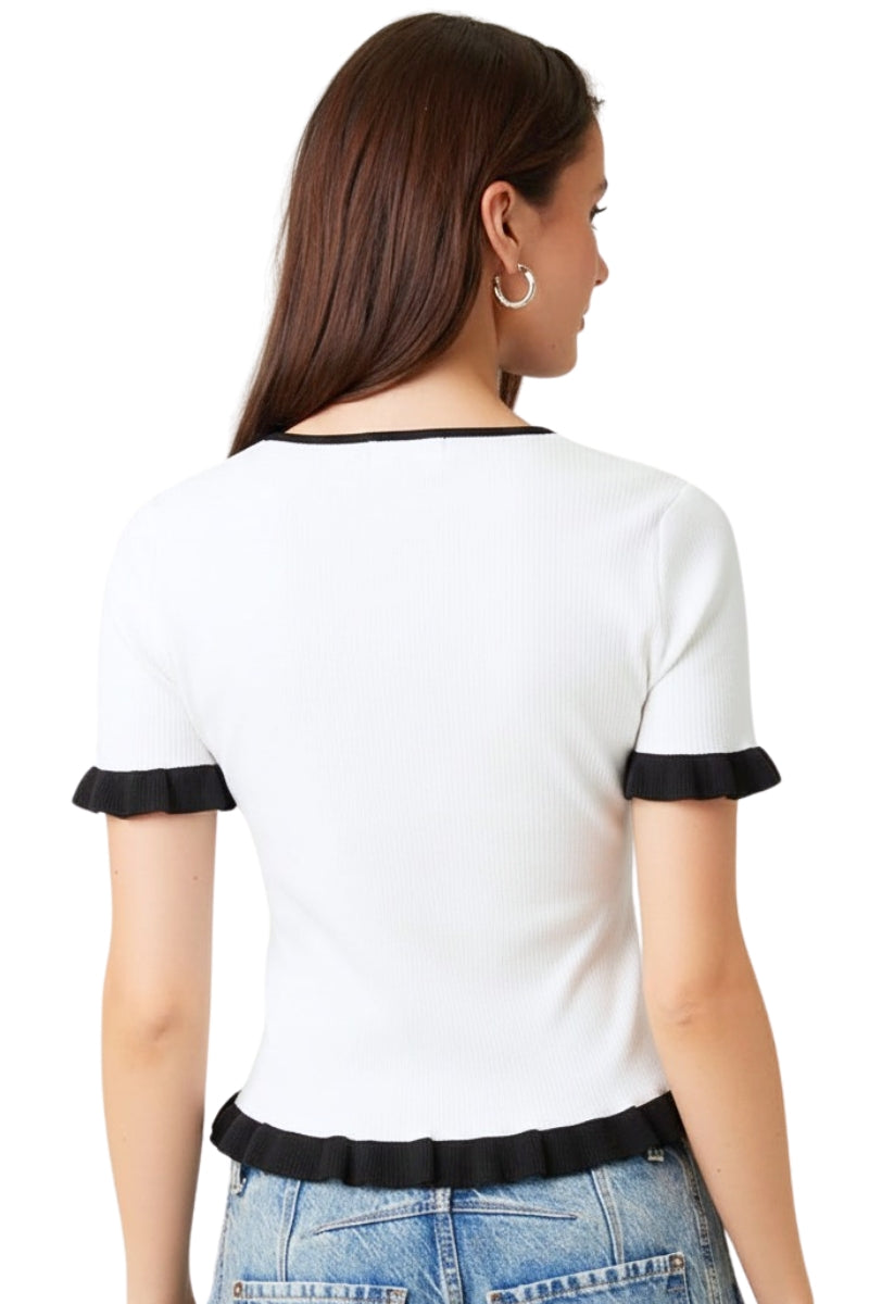Woman wearing a white blouse with black trim on a white background
