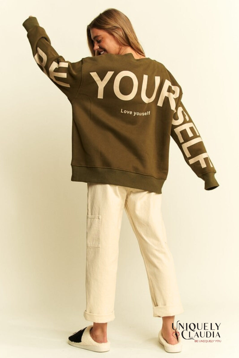 Woman wearing a green sweatshirt and beige pants 