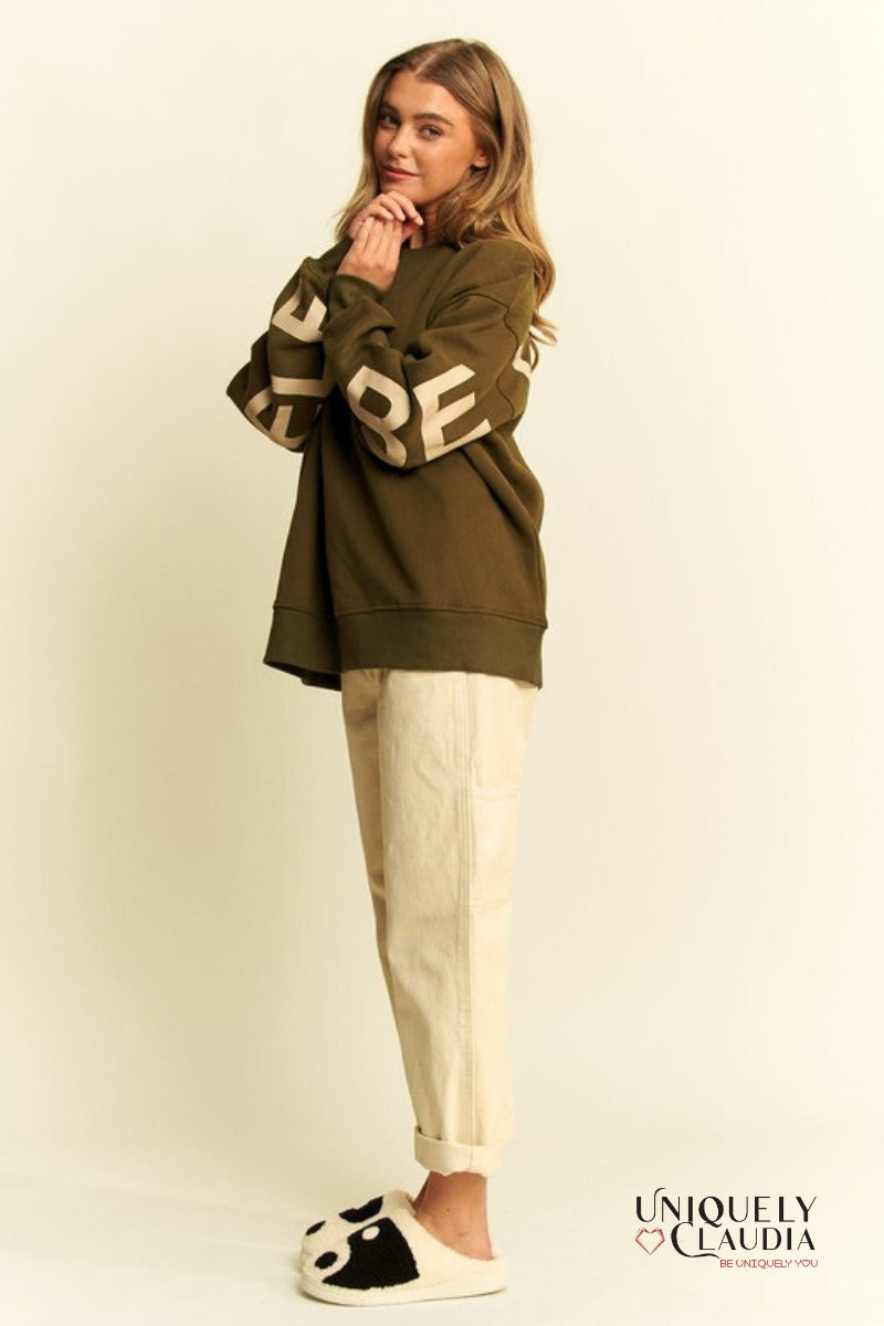 Woman wearing a green sweatshirt and beige pants
