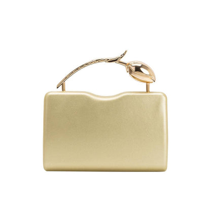Gold clutch bag with a decorative handle on a white background