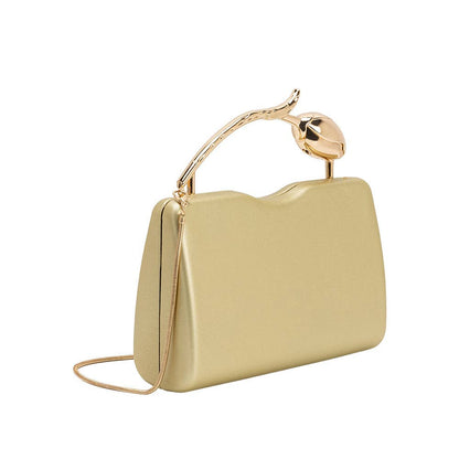 Gold clutch bag with a decorative handle on a white background