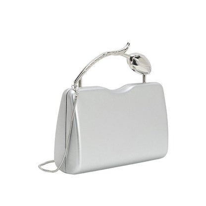 Silver clutch bag with unique handle design on a white background