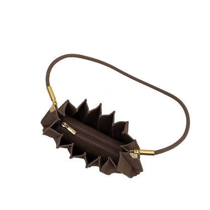 A dark brown textured leather shoulder bag with a unique ruffled, accordion-like exterior and a thin matching leather strap, accented with gold-tone hardware.