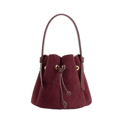 A burgundy suede bucket bag with a single shoulder strap, drawstring closure, and gold-tone hardware, shown against a plain white background.