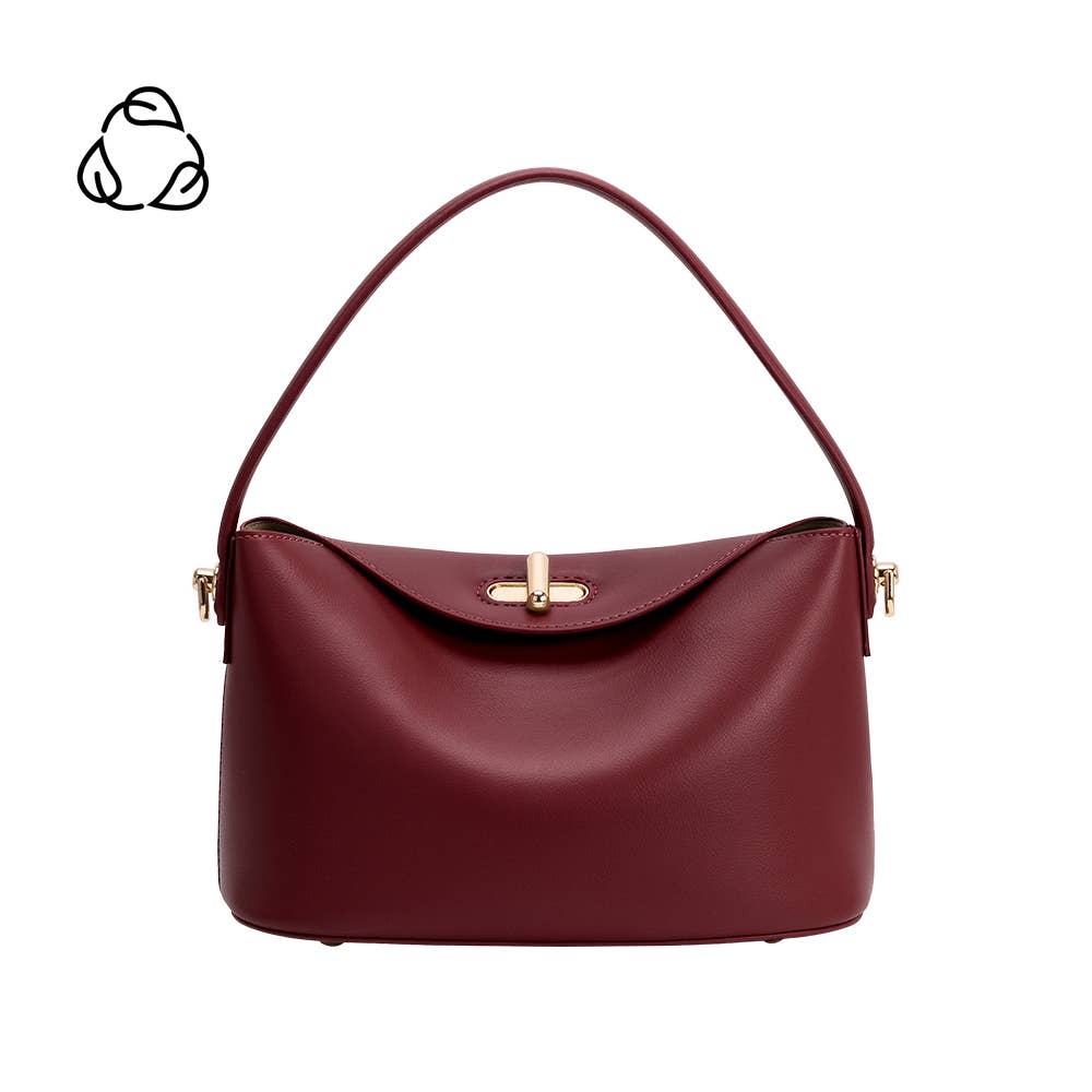 A structured leather handbag in deep burgundy with a curved top handle and gold-tone hardware, shown on a plain white background. A small black recycling symbol is visible in the top-left corner.