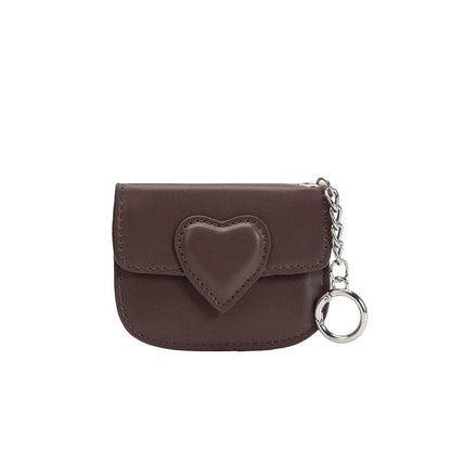 Brown leather pouch with heart design and chain on a white background