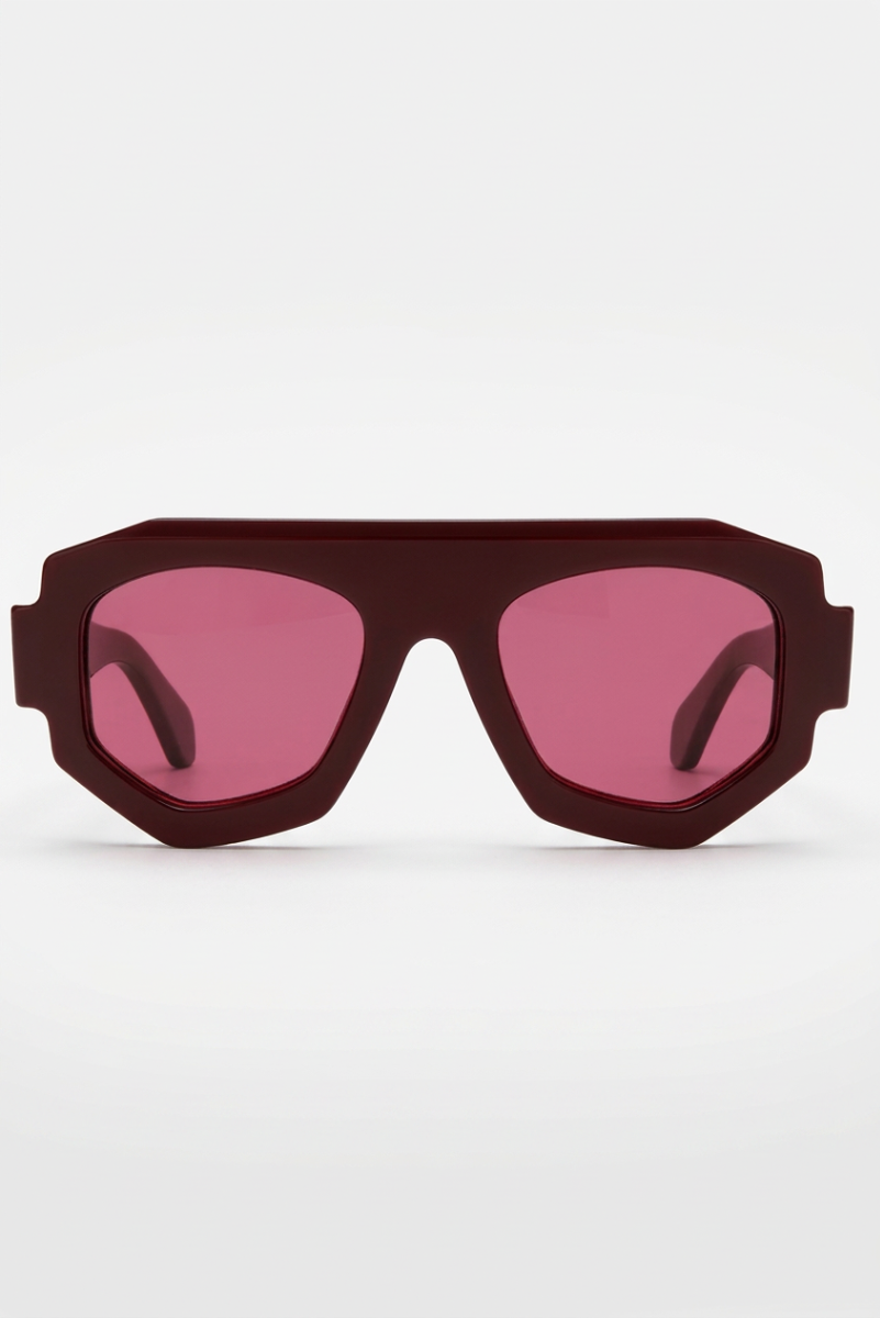 A pair of oversized shield-style sunglasses with a matte dark red frame and pink-tinted lenses, shown against a plain white background.
