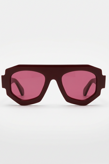 A pair of oversized shield-style sunglasses with a matte dark red frame and pink-tinted lenses, shown against a plain white background.