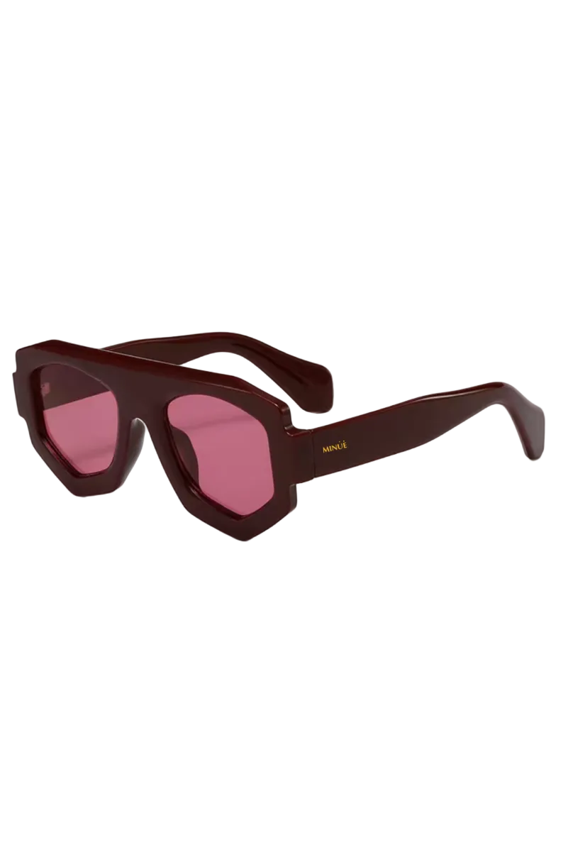 Hexagonal aviator-style sunglasses with a glossy dark burgundy acetate frame and pink tinted lenses, featuring a small gold logo on the temple arm.