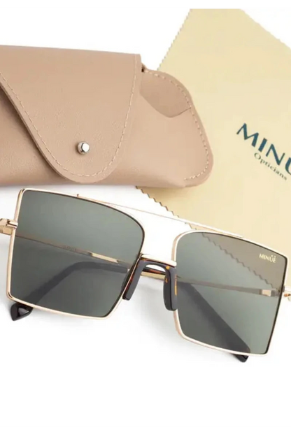 Square metal-frame sunglasses with dark tinted lenses, shown with a beige leather case and a branded MINÚE Opticians cloth on a white background.