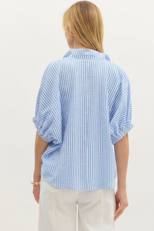 Person wearing a blue and white striped shirt on a plain background