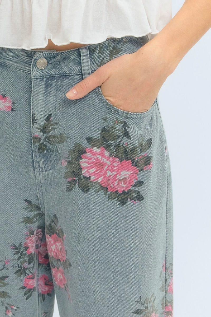 Denim pants with floral patterns worn by a person.