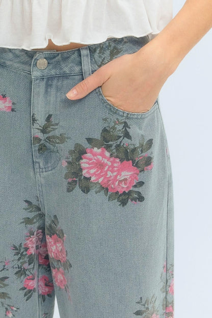 Denim pants with floral patterns worn by a person.