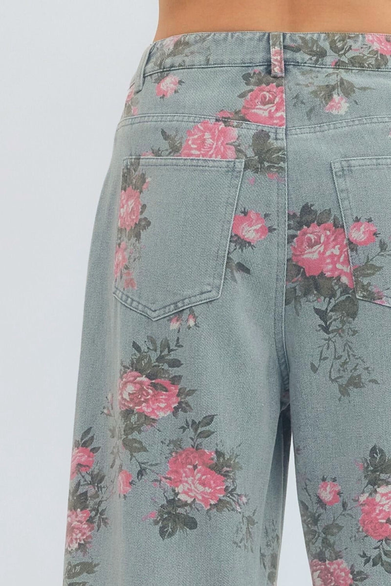 Floral-patterned jeans with pink flowers on a light blue denim background