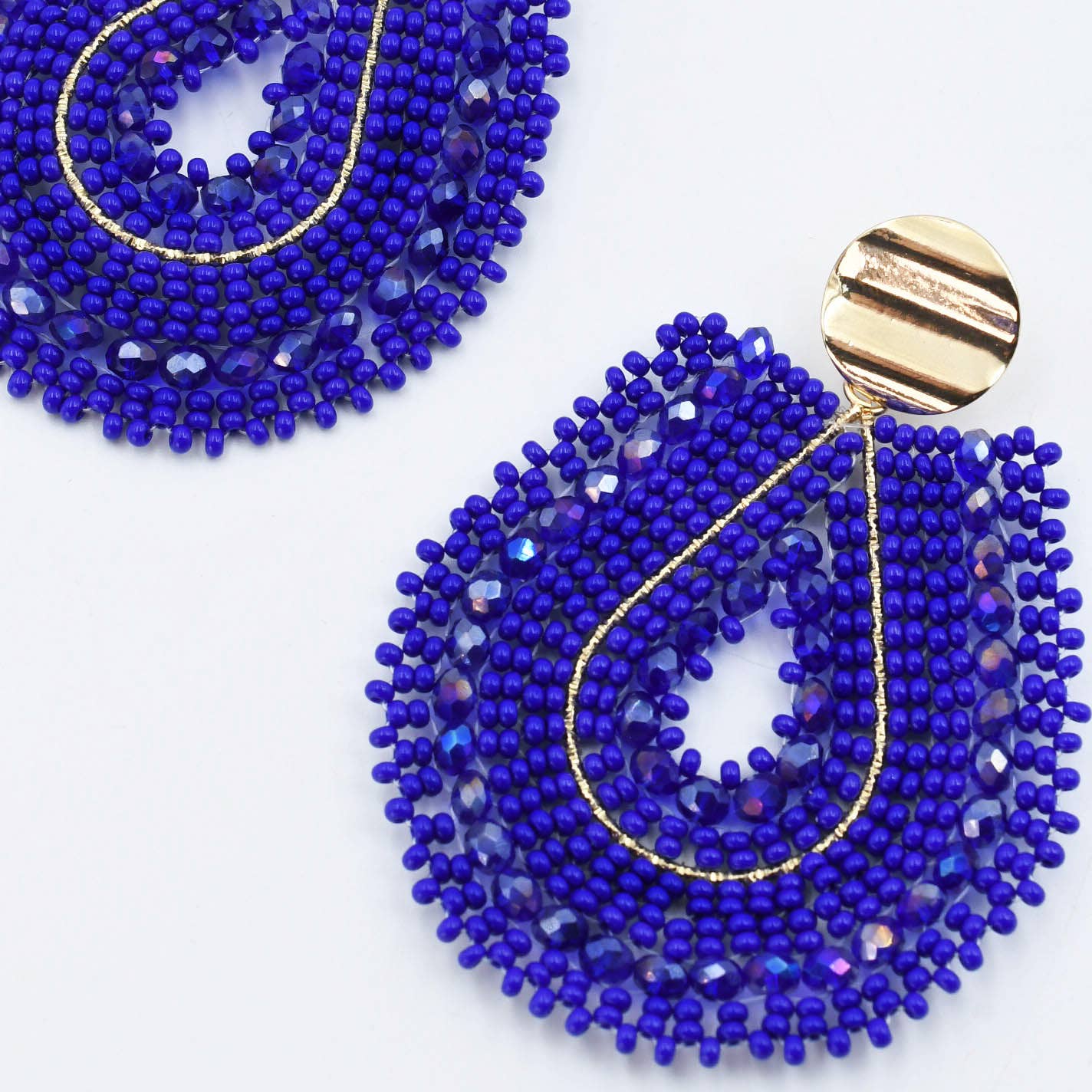 Blue beaded earrings with gold accents on a white background