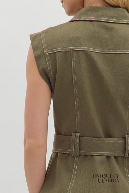 Green sleeveless dress with a belt on a plain background
