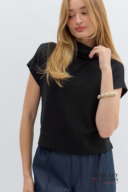 Woman wearing a black top and blue pants on a white background