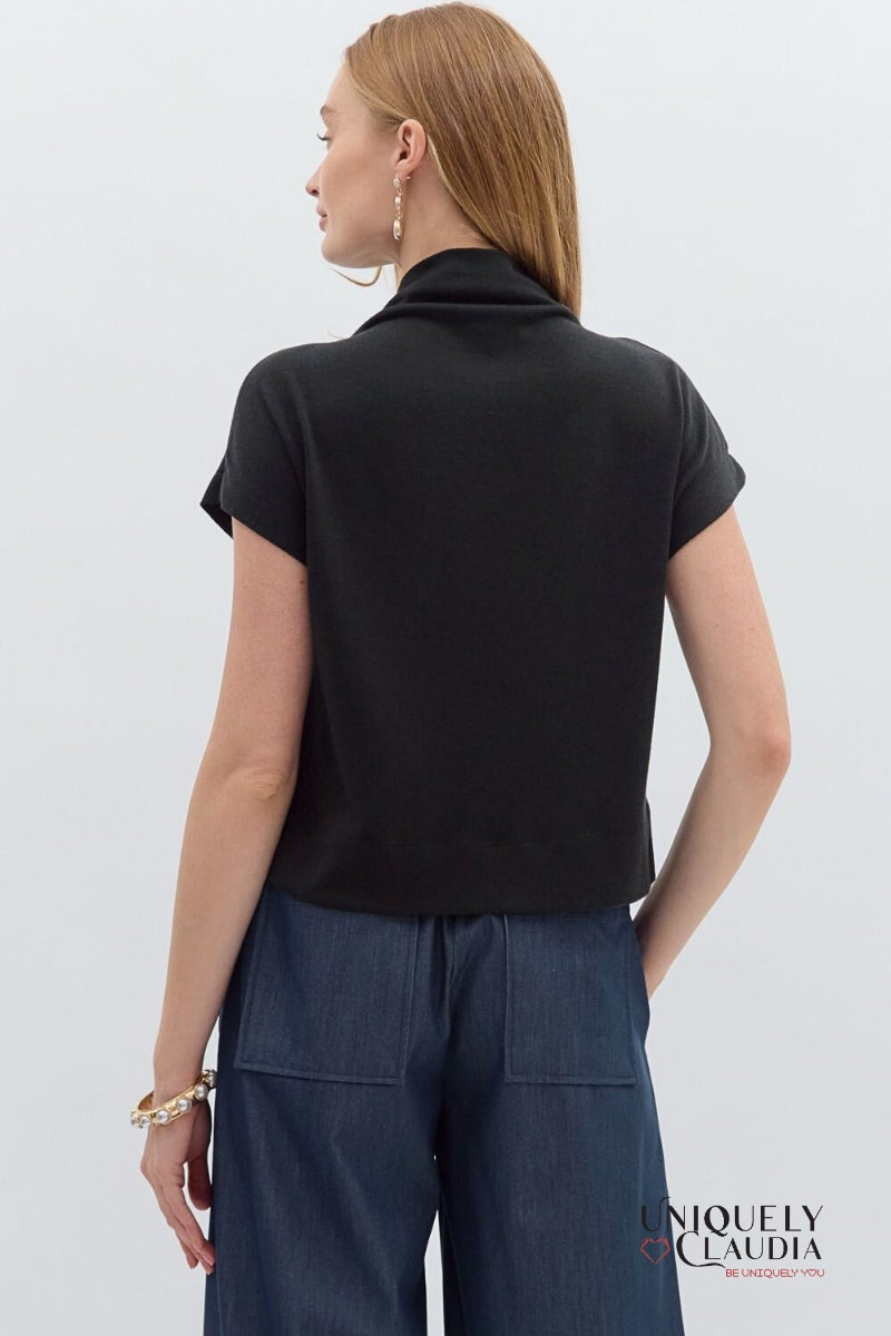 Woman wearing a black top and dark pants on a white background with 'Uniquely Claudia' branding.