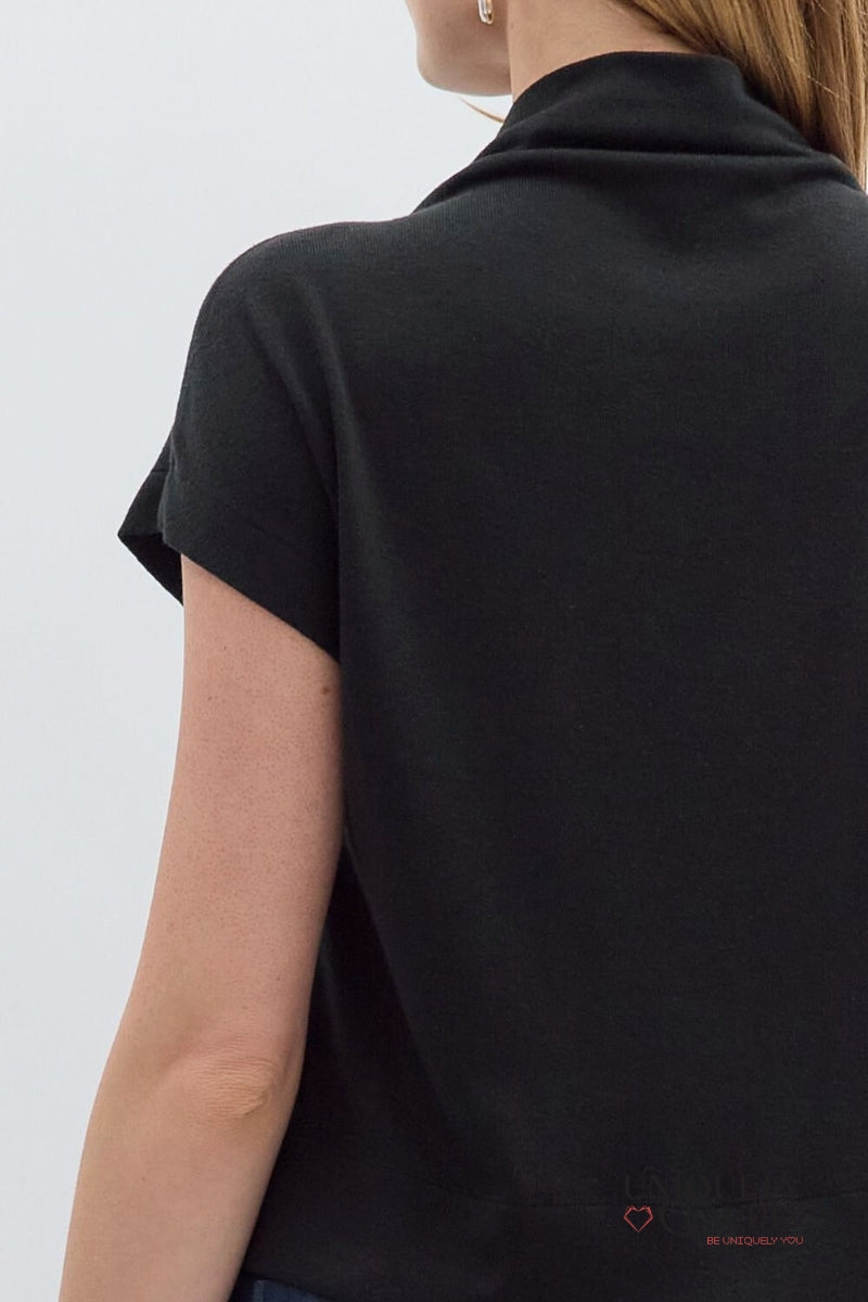 Black turtleneck shirt worn by a person on a light gray background