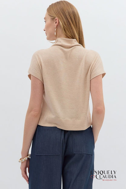 Woman wearing a beige top and navy pants on a white background with 'Niquely Claudia' branding.
