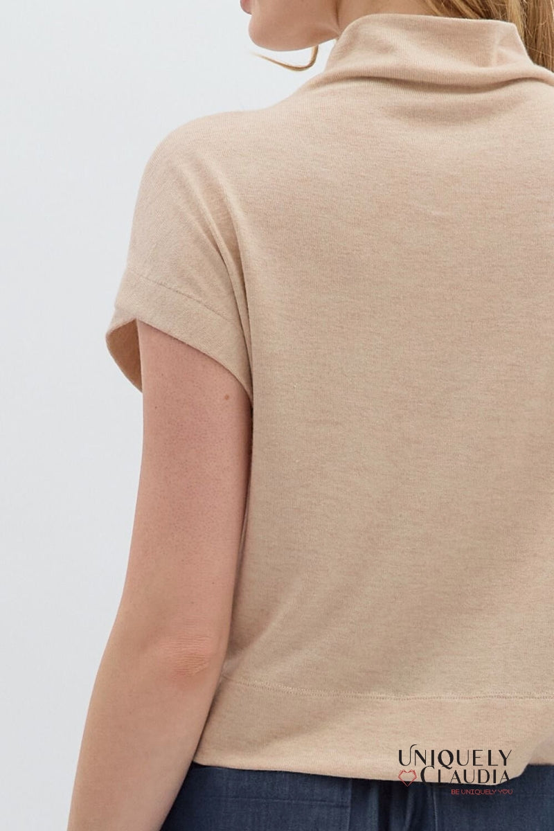 Beige sleeveless top worn by a person on a white background, with 'UNIQUELY CLAUDIA' branding.