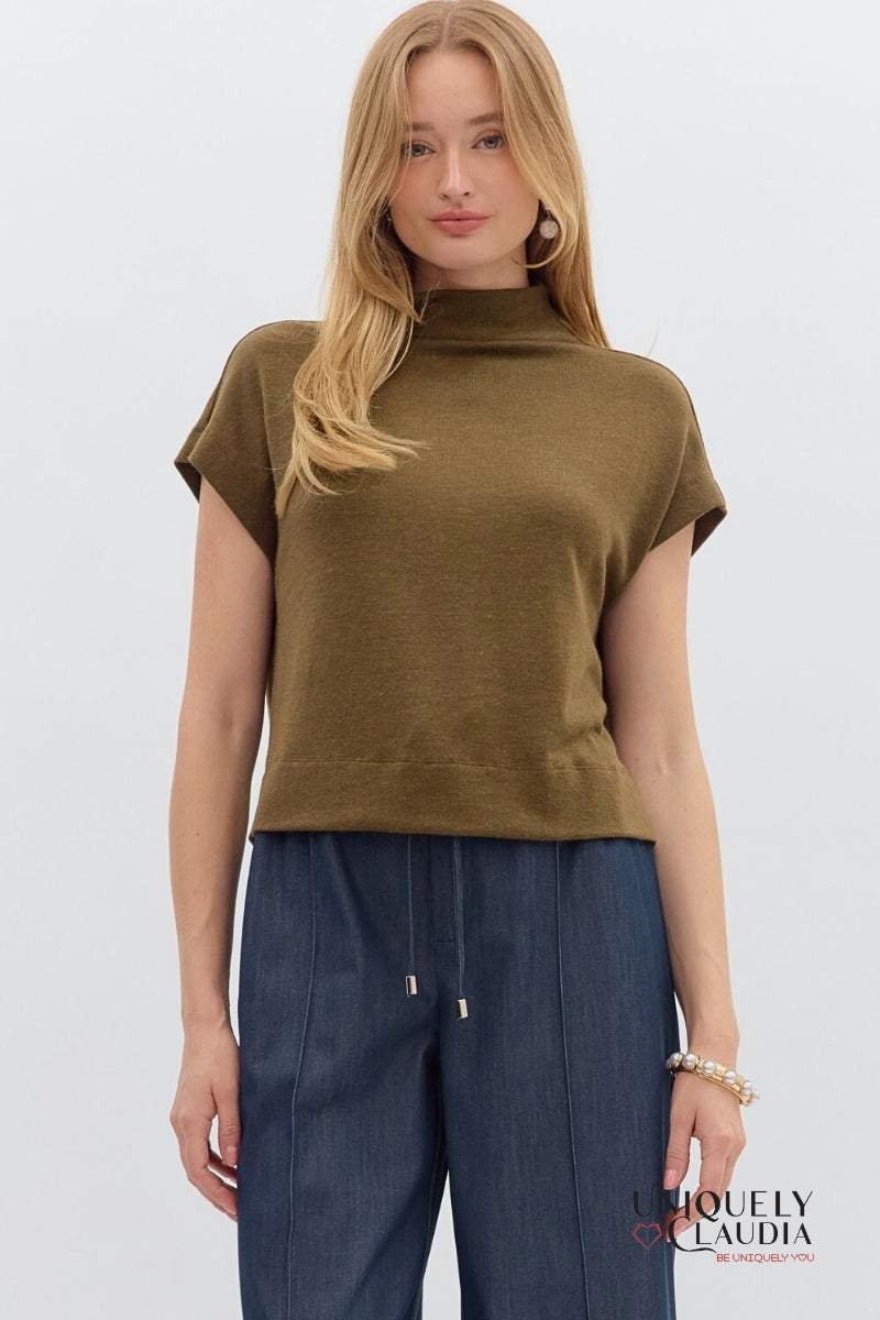 Woman wearing a brown sleeveless top and blue pants on a white background