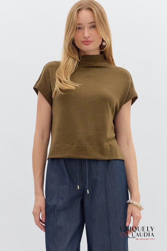 Woman wearing a brown sleeveless top and blue pants on a white background