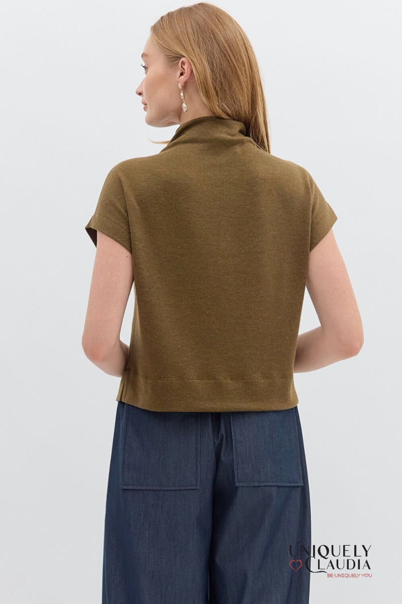 Woman wearing a brown sleeveless top and blue pants on a white background with 'Uniquely Claudia' branding.