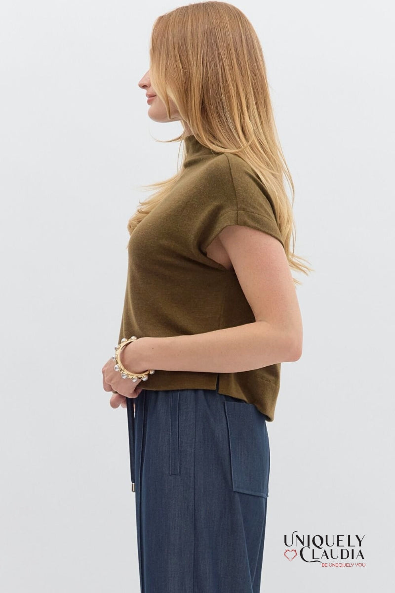 Woman wearing a brown sleeveless top and blue pants on a white background with 'Uniquely Claudia' branding.