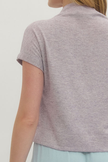 Person wearing a light gray polo shirt against a white background