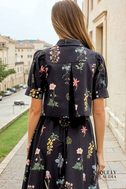 Woman wearing a black floral dress walking on a street.