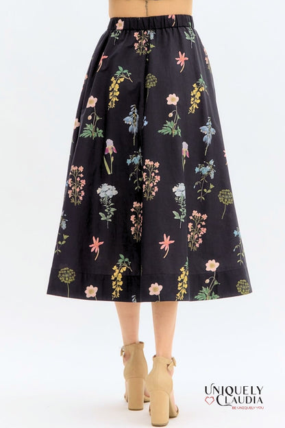Floral-patterned black skirt on a white background with 'UNIQUELY CLAUDIA' branding.
