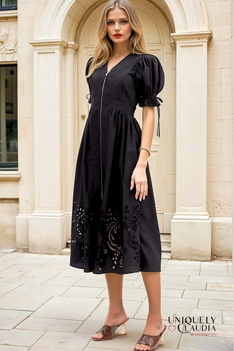 Woman wearing a black dress with floral details in an urban setting