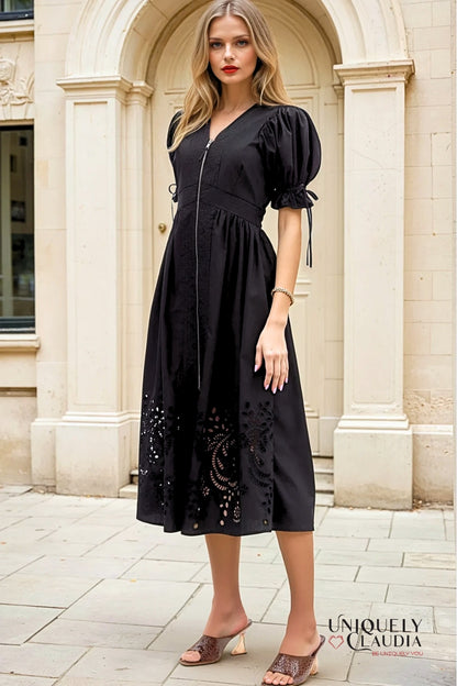 Woman wearing a black dress with floral details in an urban setting