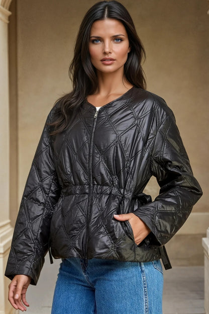 Woman wearing a black quilted jacket with a neutral background