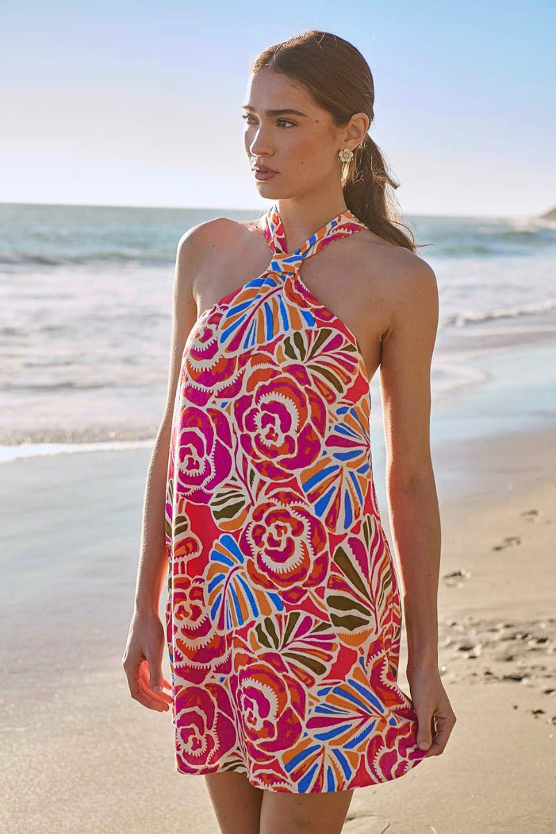 Woman wearing a colorful floral dress on a beach