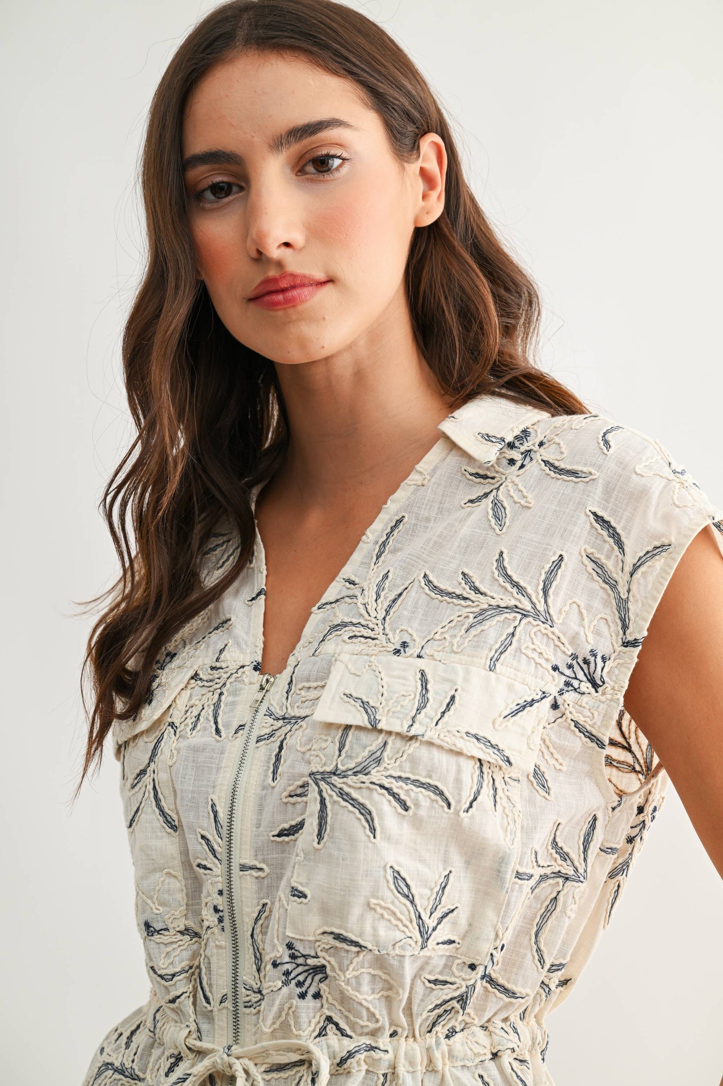 Woman wearing a floral dress against a plain background